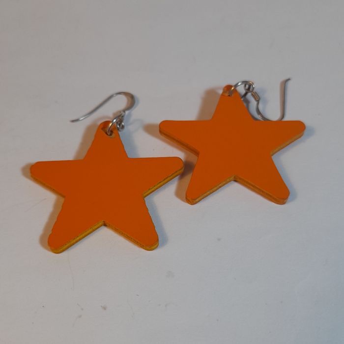 Brincos em Madeira com design de estrelas.
