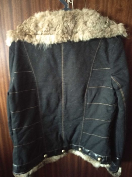 Casaco preto em tecido aveludado com botões dourados e gola de pêlo.