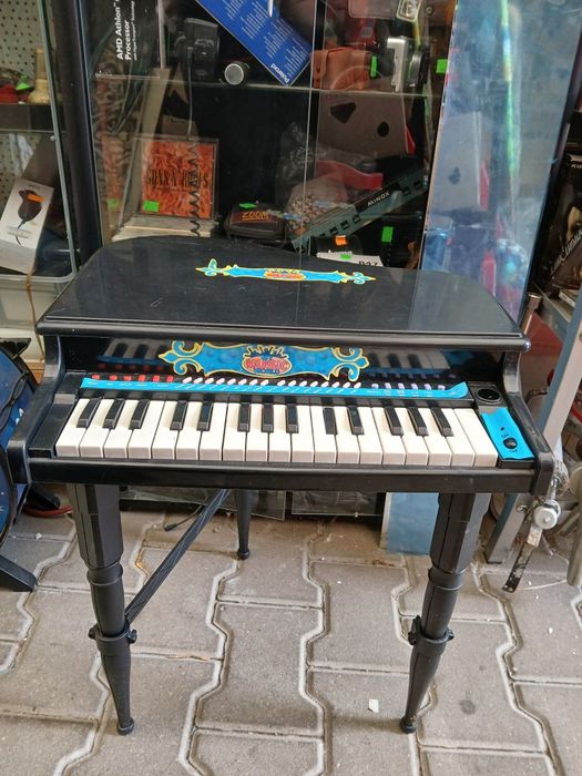 czarne, plastikowe pianino-zabawka w kształcie mini fortepianu