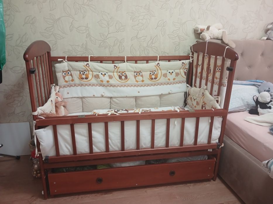 Дитяче ліжечко на маятнику з шухлядою, бортиками і постільною білизною