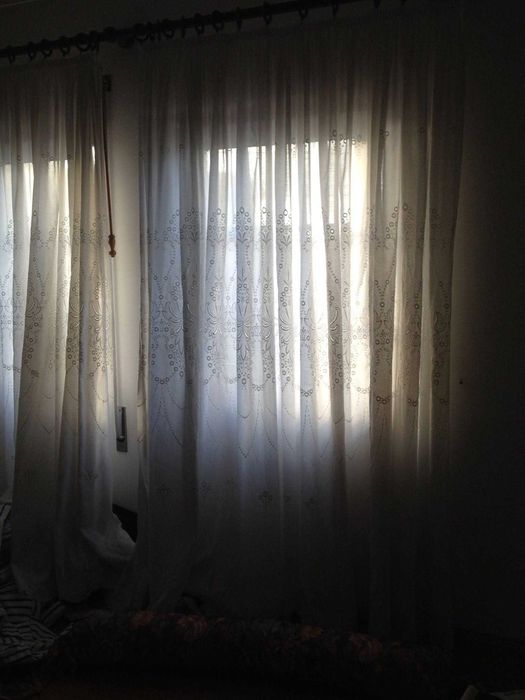 Cortinados em linho creme e bordados com varão