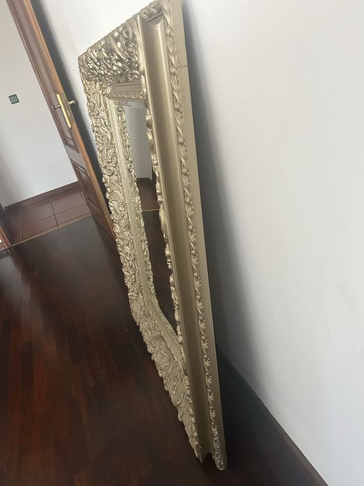 Espelho com moldura dourada.