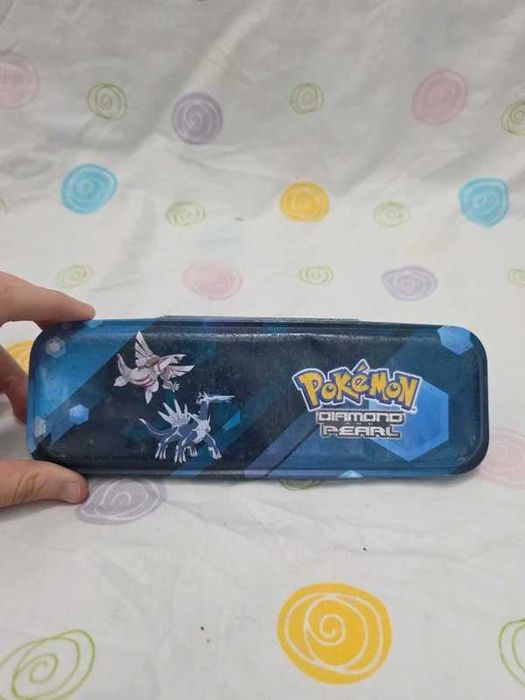 estojo de metal do Pokémon com o Palkia e o dialga nele