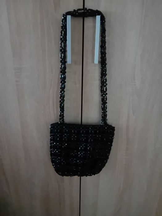 Torebka koloru czarnego z koralików na dłuszych paskach .