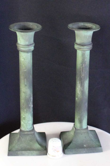 Par de castiçais antigos de latão com pátina esverdeada.