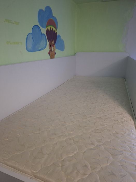 Двох ярусне ліжко, зі столом внизу.