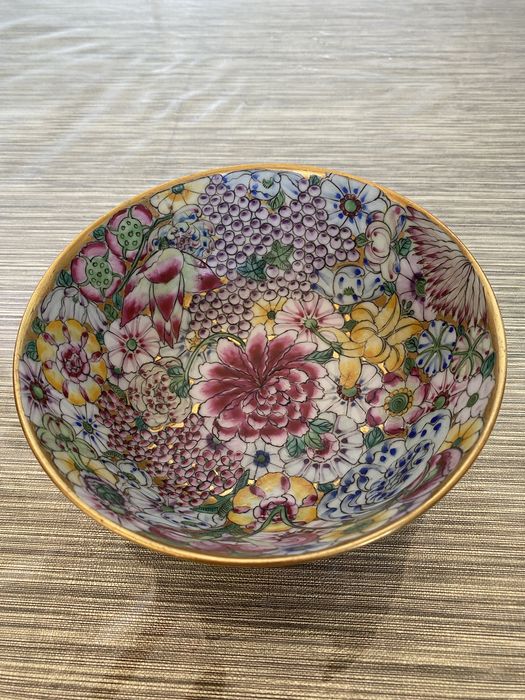 Um prato com fundo rosa e dourado e um padrão de flores