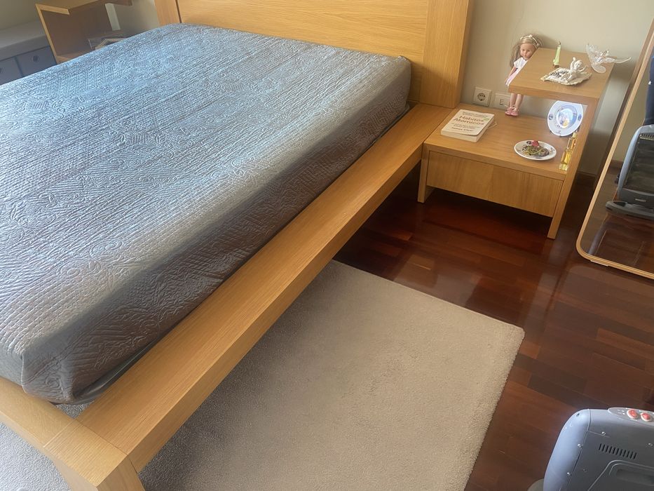 Quarto com cama de casal, colchao e mesinhas de cabeceira