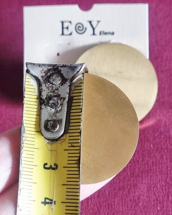 Brincos dourados, em aço, redondos e ondulados. Cerca de 3,5cm de diâmetro.