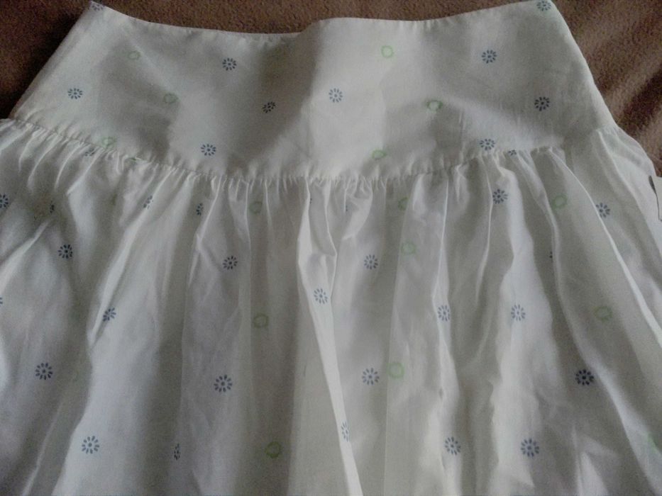 Saia curta, fundo branco e barra florida