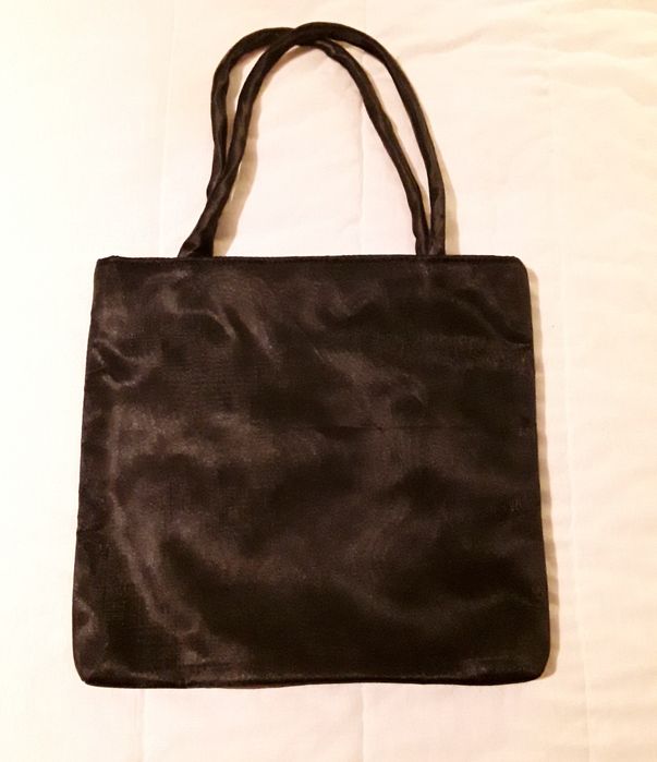 Bolsa ou mala de mão preta com aplicação circular vermelha