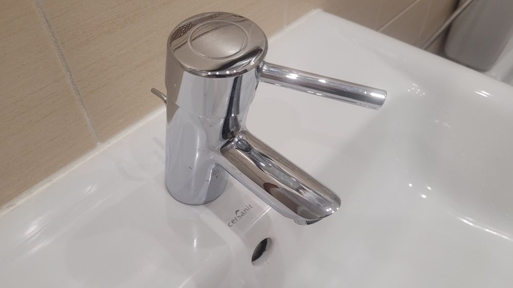 Cersanit, słupek, szafka z umywalką oraz bateria łazienkowa.