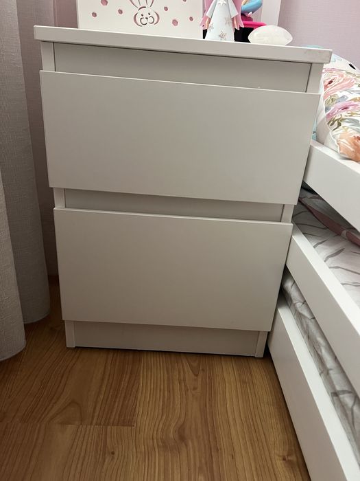 Cama de crianca com mesinha de cabeceira.