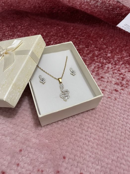 conjunto de colar e brincos dourados com simbolo de uma cobra