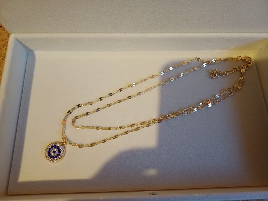 Colar dourado de duas voltas, com pingente de olho grego. Novo.