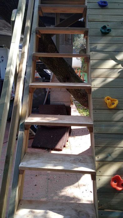 Casinha na árvore com parede de escalada