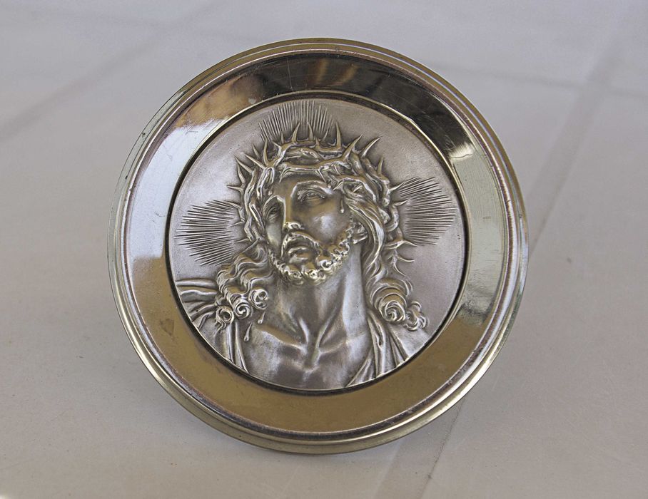 Medalhão em prata, com imagem de Cristo em baixo relevo, usado