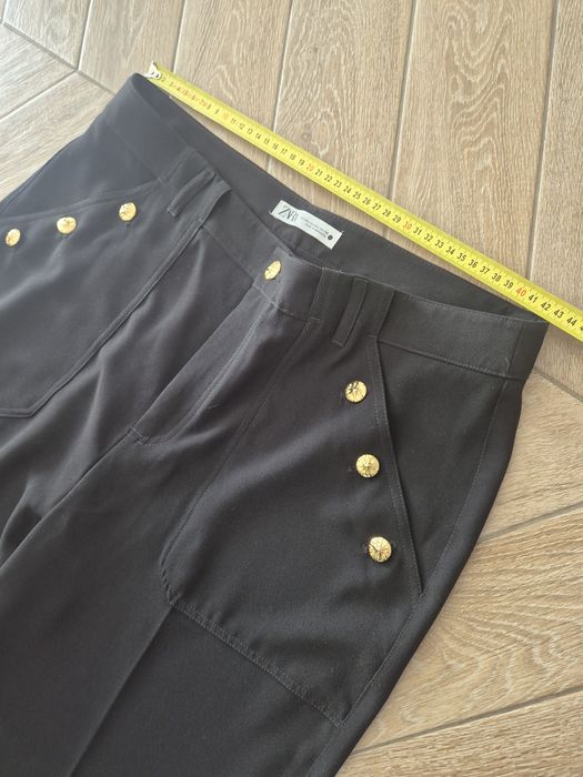 Czarne eleganckie spodnie damskie z szeroką nogawką i rzędowymi guzika