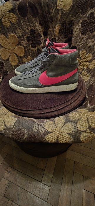 To są szare zamszowe buty Nike Blazer Mid z czerwonymi akcentami.