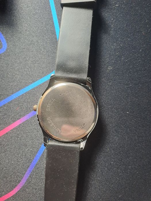 Relógio preto e dourado com pedrinhas