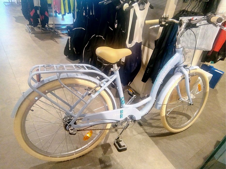 Bicicleta de cidade em azul claro, com cesto frontal e grade traseira. Extremamente elegante e bonita.