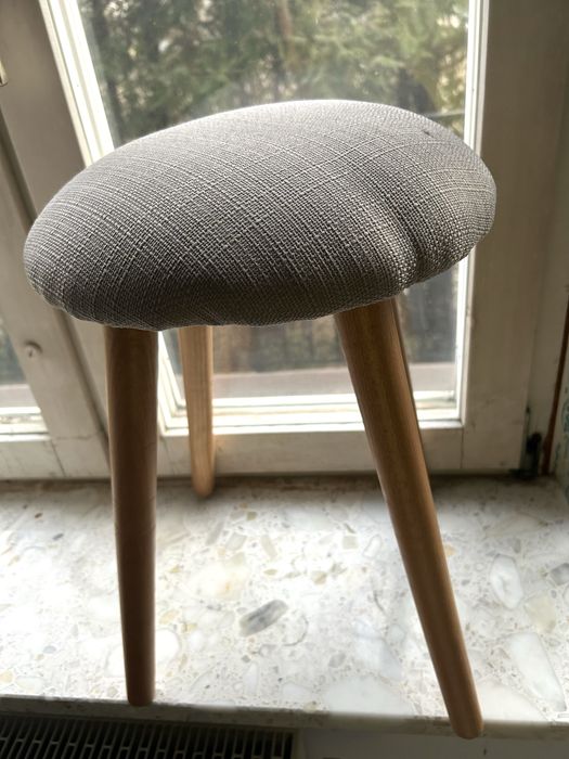 Szary tapicerowany stołek z drewnianymi nogami nowy bez metki