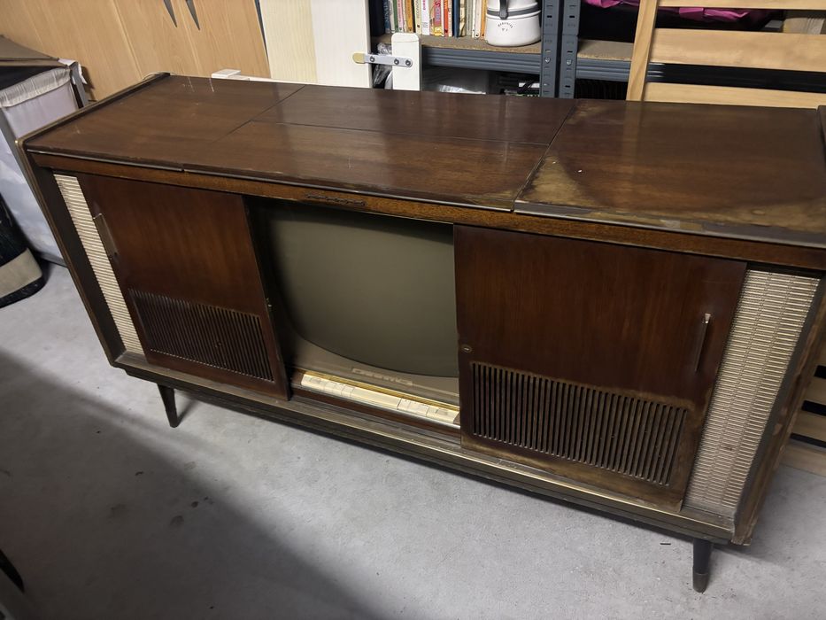 Movel rádio-giradiscos vintage dos anos 60 em madeira escura com grelha de coluna em tecido bege