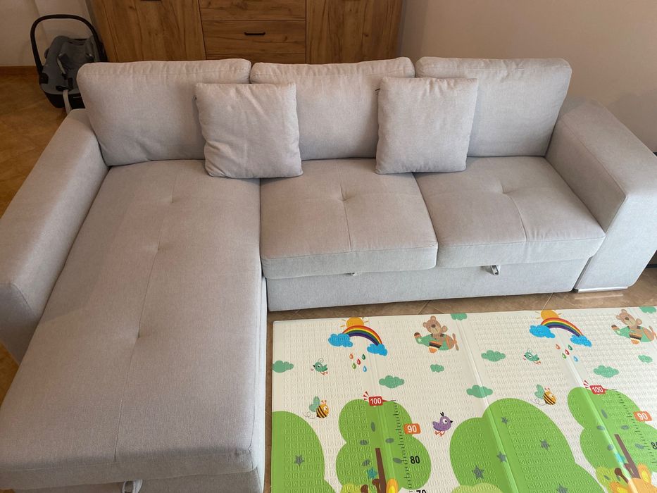 Sofá cinzento com chaise long e cama