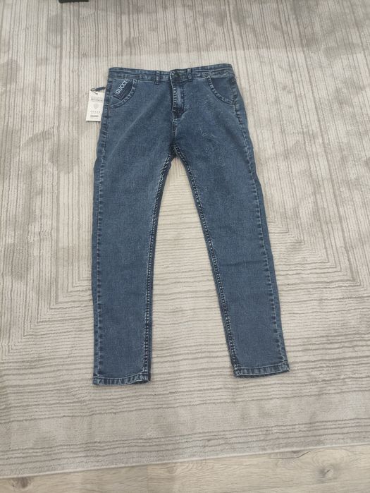 Jeansy do kostek z napisem Gucci