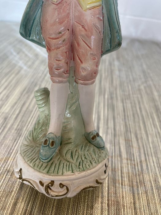 Estátua em cerâmica de um homem que segura um violino