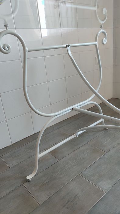 Mesa em ferro forjado com tampo de vidro.