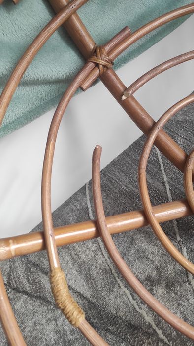 Duży fotel wiklinowy z poduszką.