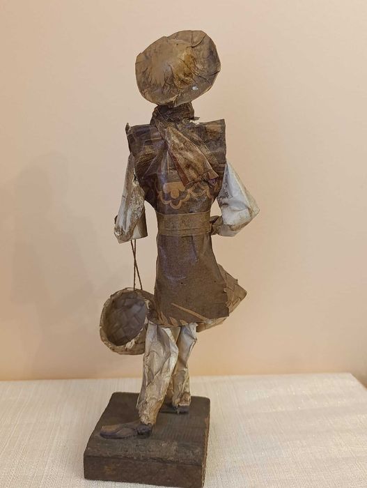 Figura de artesanato homem em papel maché com cestos