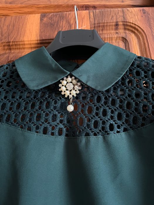 Смарагдова блуза з мереживом і брошкою