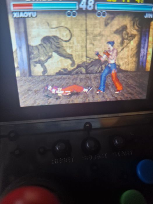 consola portátil retro a correr o jogo Tekken Advance.