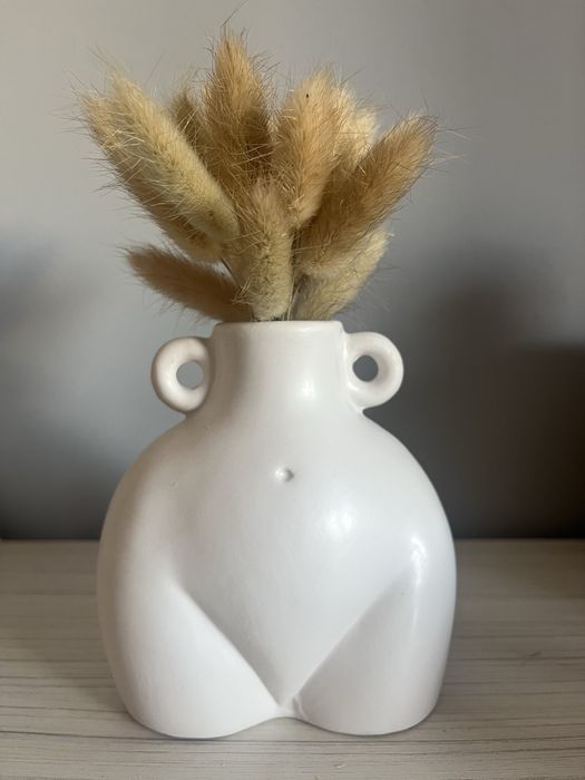 Biały wazon w kształcie talii kobiety z kłosami