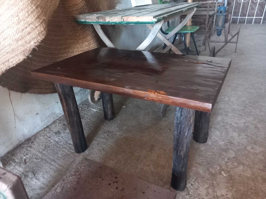 Mesa rústica de madeira maciça, antiga, tampo retangular espesso, pernas robustas em troncos roliços escurecidos