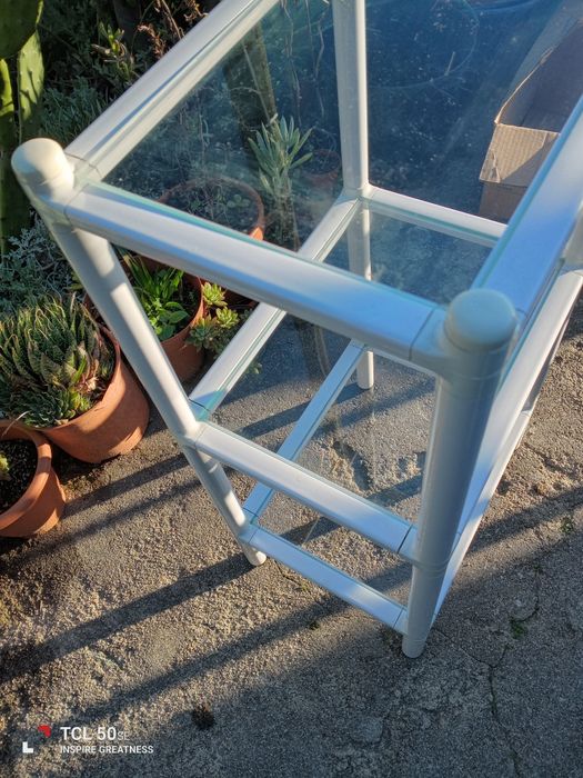 Estante com três prateleiras em vidro. Em bom estado