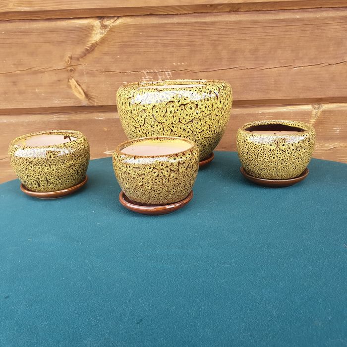 Żółta doniczka ceramiczna z przytwierdzoną podstawką