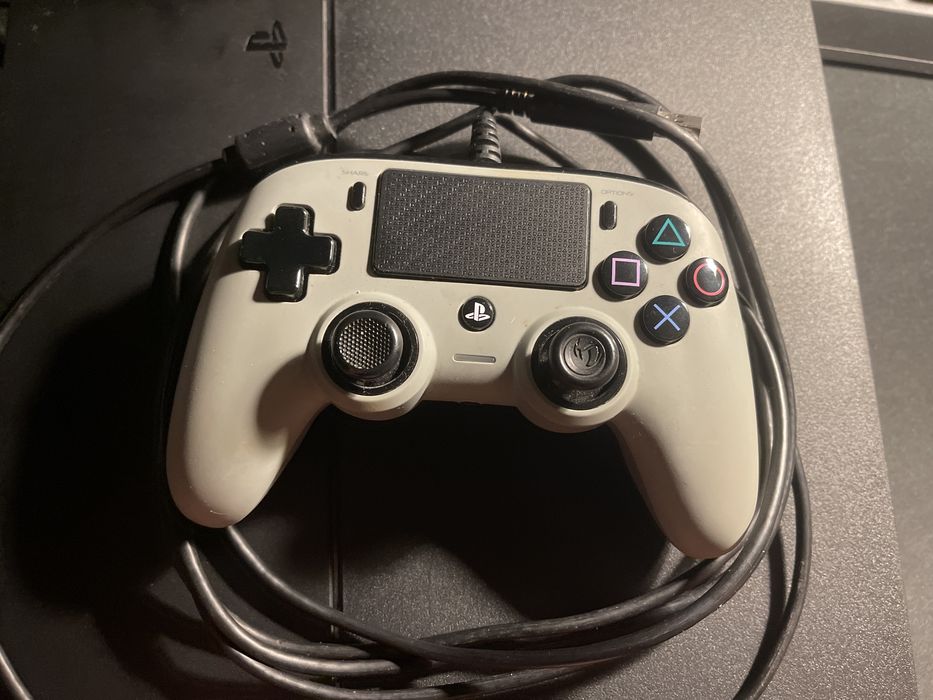 Consola ps4, três comandos e uma capa de um comando