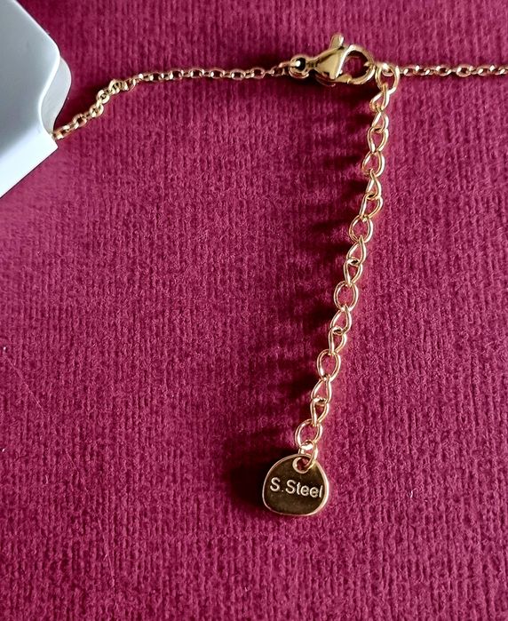 Colar dourado, em aço, com 5 pequenos corações em pedra de vidro.