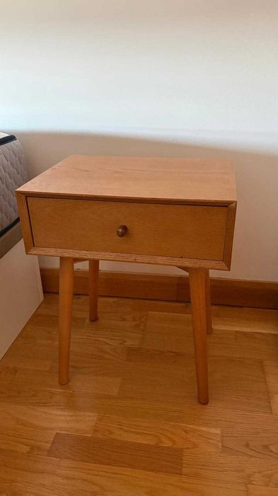 Mesas de cabeceira em madeira clara, com design simples e moderno.