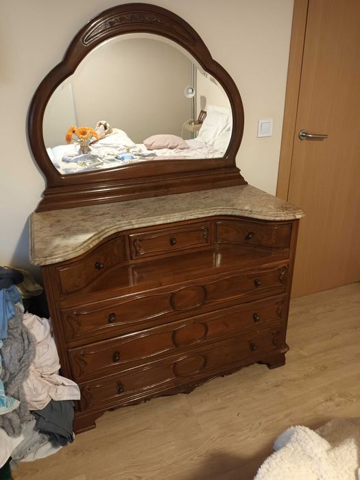 Móveis guarda vestidos, cama, cómoda e mesinhas de cabeceira.