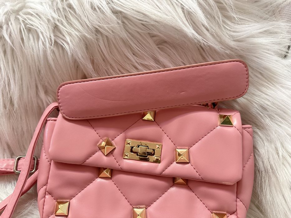 Mala cor de rosa com tachas