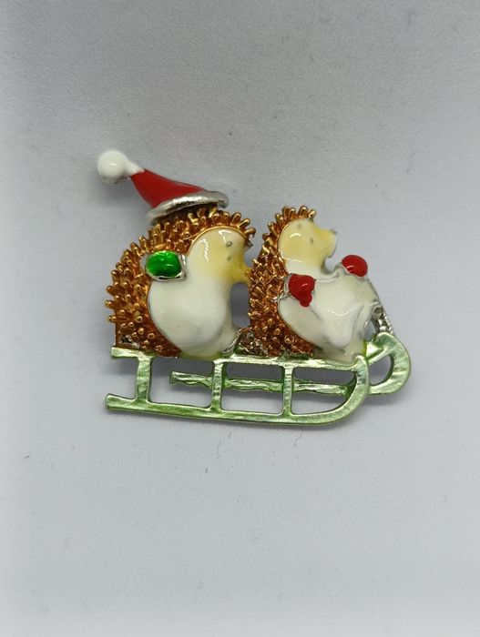 Piękna broszka jeżyki na sankach