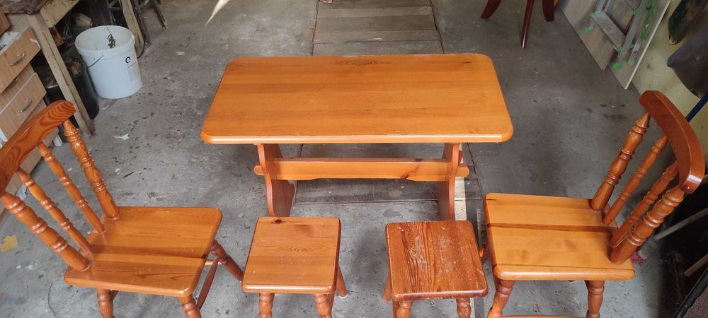 Stół drewniany z 2 krzesłami i 2 stołkami.