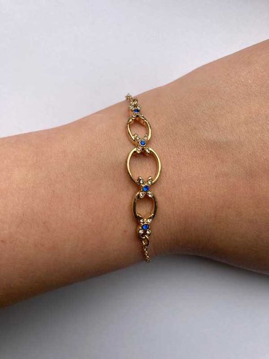 Złota bransoletka z niebieskimi i białymi kamyczkami