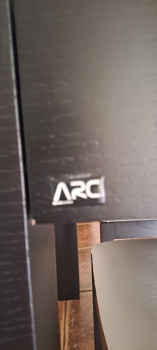Mesa de jantar extensível em carvalho escuro com tapo de vidro preto.