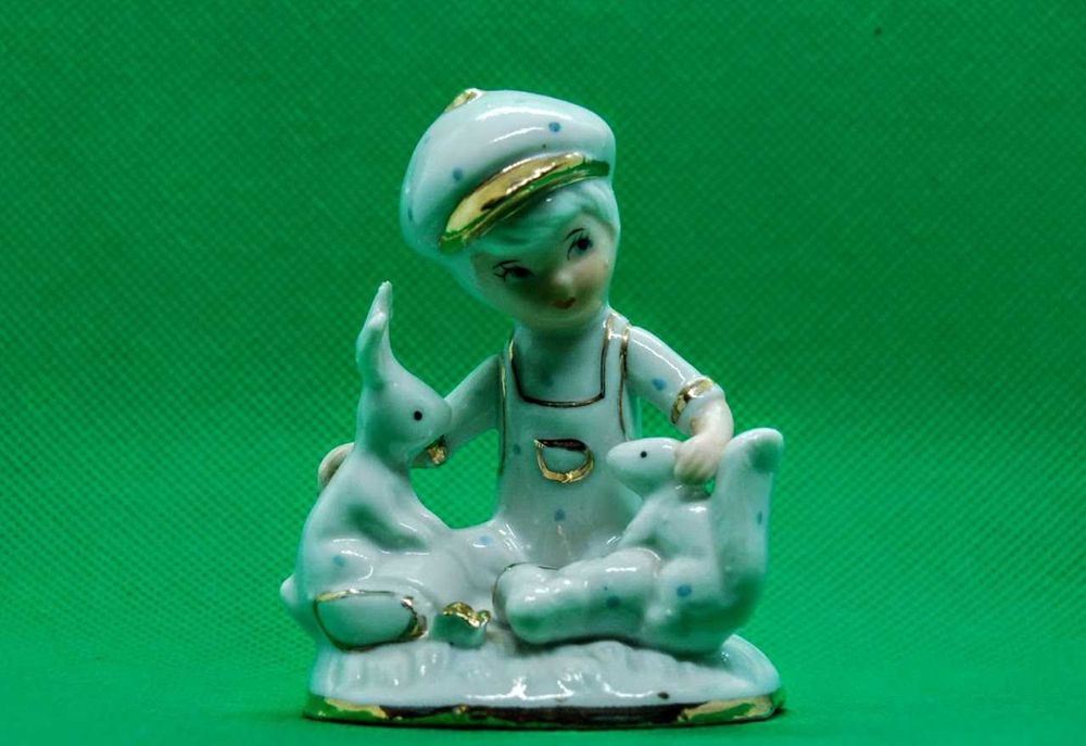 Estatueta antiga de menino em porcelana