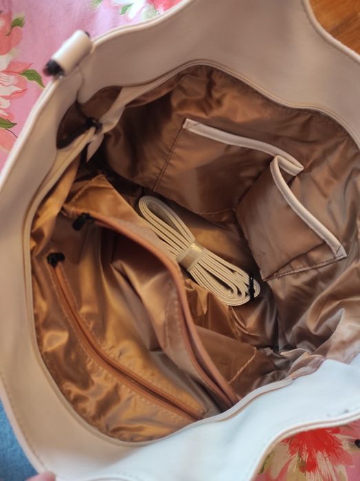 Світло бежева сумка з штучної шкіри з бахромою.